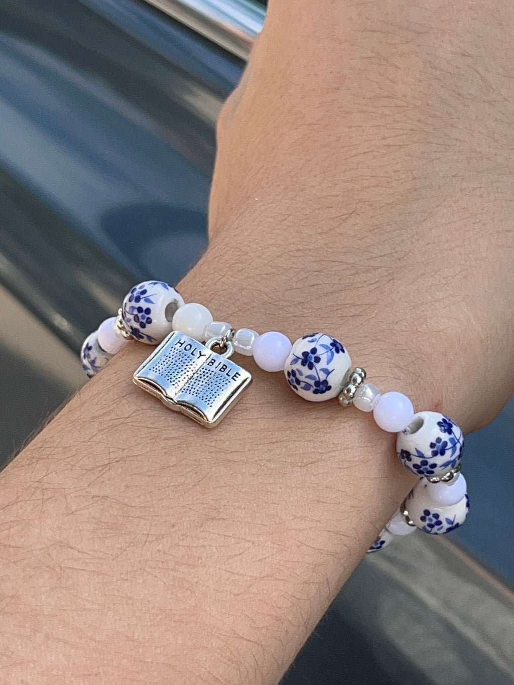 Holy Bible floral bead bracelet displayed among white flowers